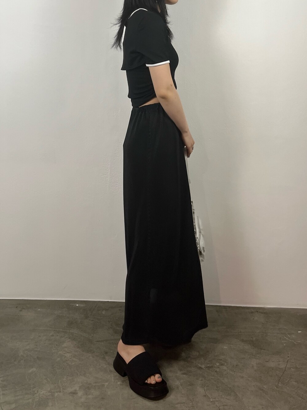 ブラック系のTシャツ/カットソー、ブラック系のスカート、ブラック系のサンダルを着用したレディースの夏コーディネートの4枚目の写真