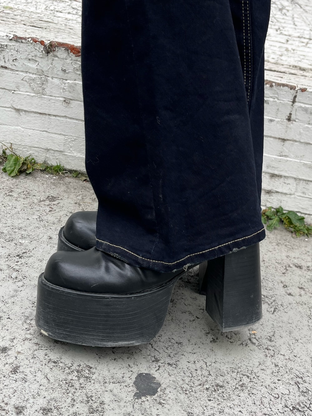 ブラック系のニット/セーター、ブルー系のデニムパンツ、ブラック系のブーツを着用したレディースの冬コーディネートの6枚目の写真