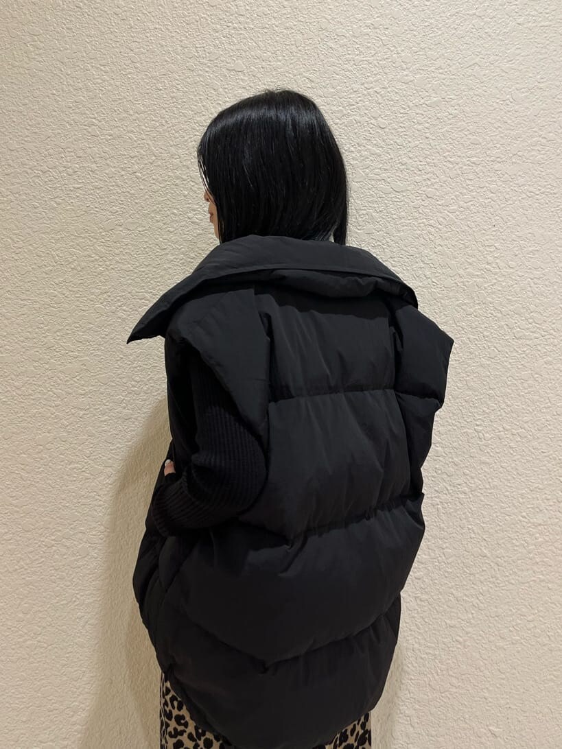 ブラック系のブーツ、ブラック系のニット/セーター、ブラック系のダウンベストを着用したレディースの秋コーディネートの6枚目の写真