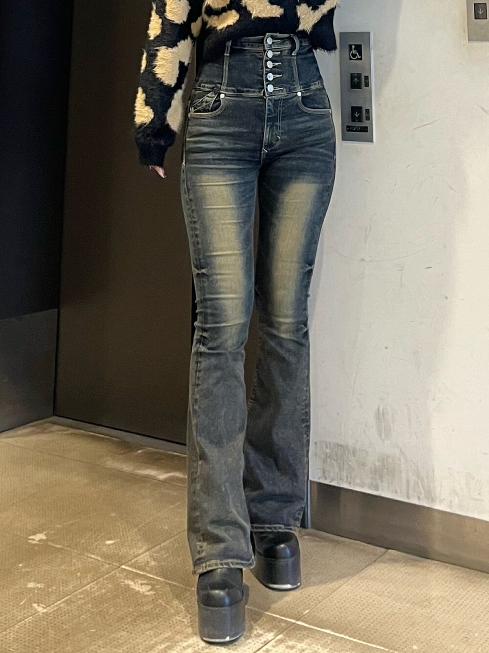 ブラック系のニット/セーター、ブルー系のデニムパンツ、ブラック系のブーツを着用したレディースの冬コーディネートの5枚目の写真