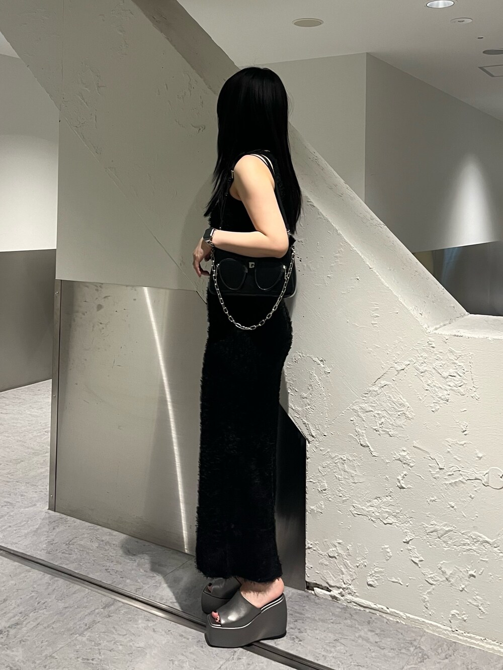 ブラック系のタンクトップ、ブラック系のスカート、ブラック系のショルダーバッグを着用したレディースの春コーディネートの3枚目の写真