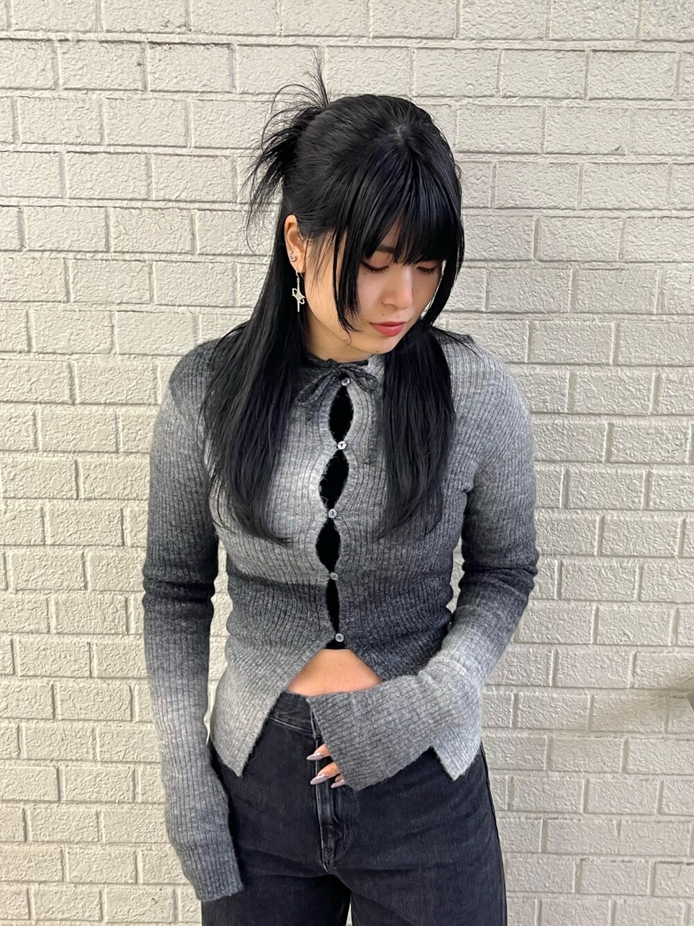 ブラック系のニット/セーター、ブラック系のデニムパンツ、ブラック系のブーツを着用したレディースの冬コーディネートの4枚目の写真