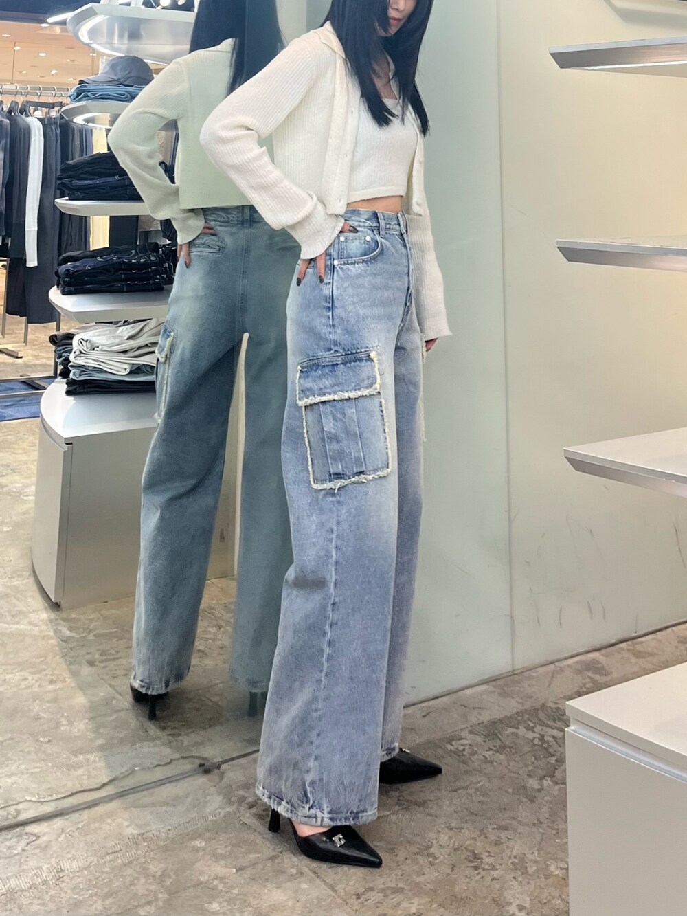 ホワイト系のニット/セーター、ブルー系のデニムパンツ、ブラック系のパンプスを着用したレディースの春コーディネートの2枚目の写真