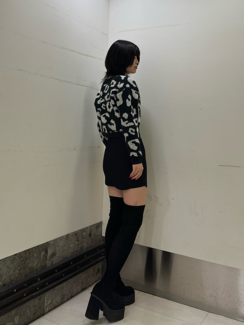 ブラック系のカーディガン/ボレロ、ブラック系のスカート、ブラック系のブーツを着用したレディースの冬コーディネートの3枚目の写真