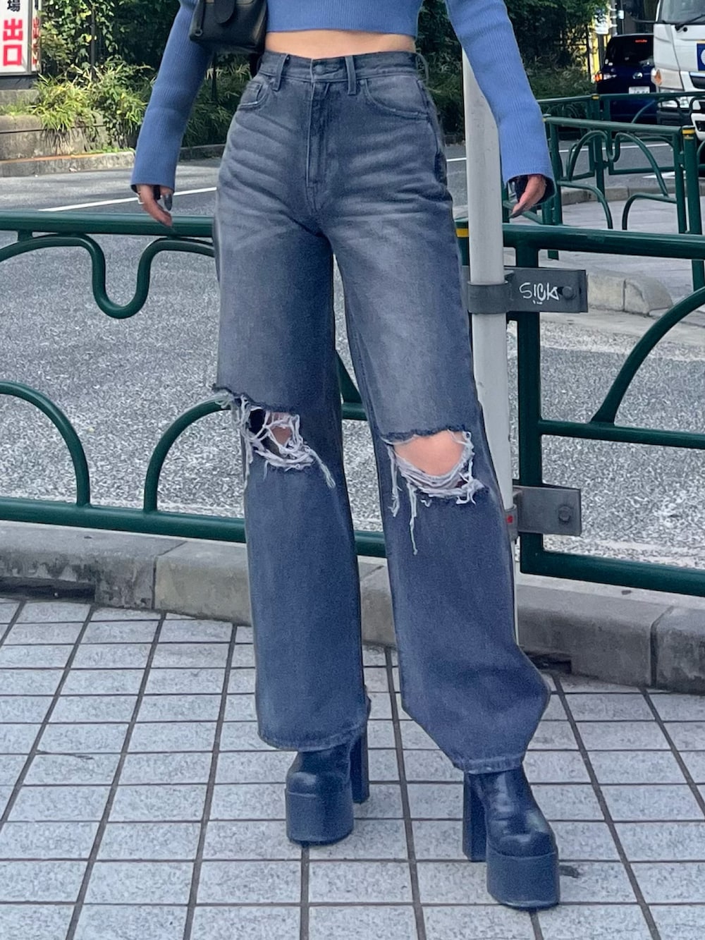 ブルー系のニット/セーター、グレー系のデニムパンツ、ブラック系のブーツを着用したレディースの秋コーディネートの6枚目の写真