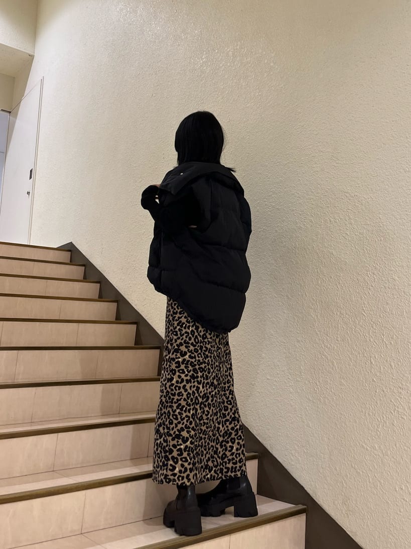 ブラック系のブーツ、ブラック系のニット/セーター、ブラック系のダウンベストを着用したレディースの秋コーディネートの4枚目の写真