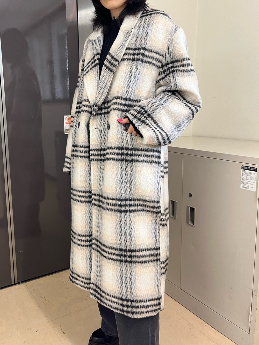 ブラック系のニット/セーター、その他のチェスターコート、グレー系のデニムパンツを着用したレディースの冬コーディネートの4枚目の写真