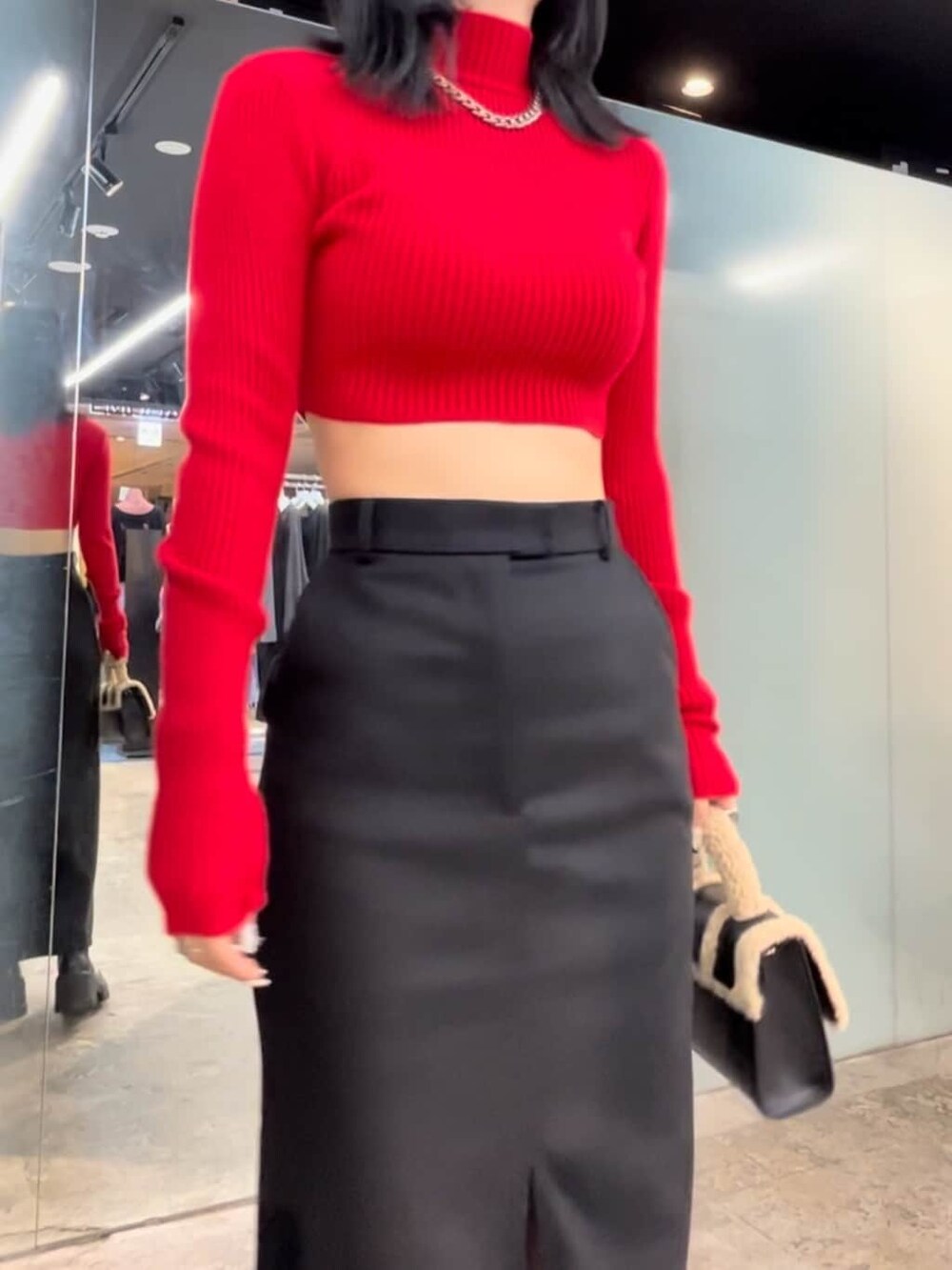 ブラック系のブーツ、レッド系のニット/セーター、ブラック系のスカートを着用したレディースの秋コーディネートの4枚目の写真