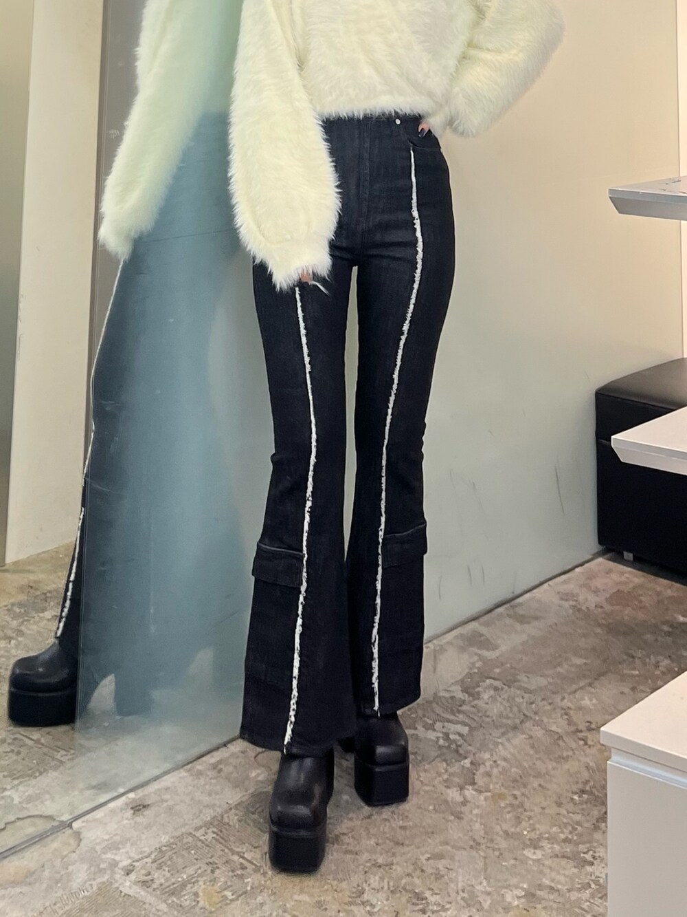 ホワイト系のニット/セーター、ブラック系のデニムパンツ、ブラック系のブーツを着用したレディースの秋コーディネートの6枚目の写真