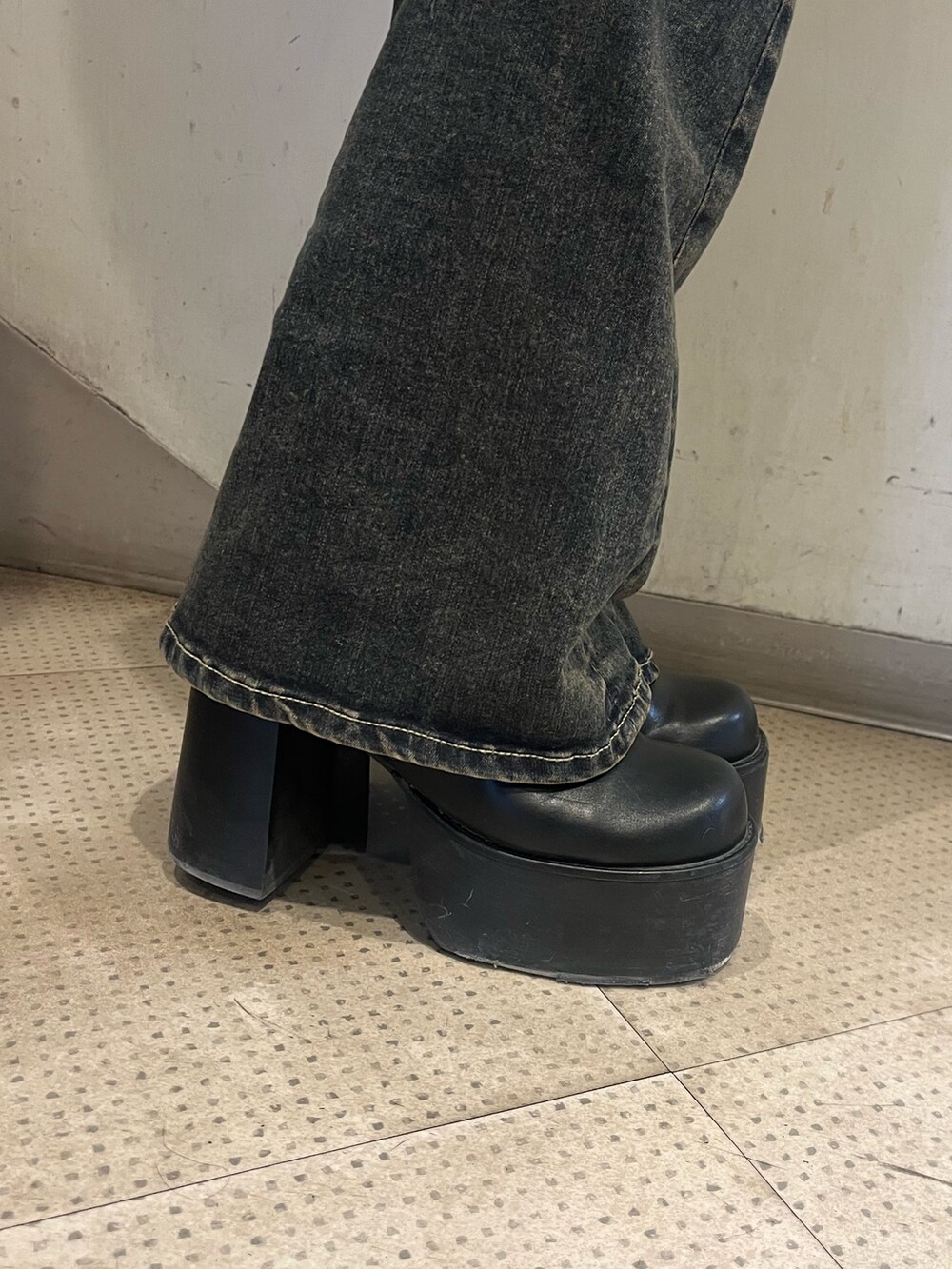 ブラック系のニット/セーター、ブルー系のデニムパンツ、ブラック系のブーツを着用したレディースの冬コーディネートの6枚目の写真