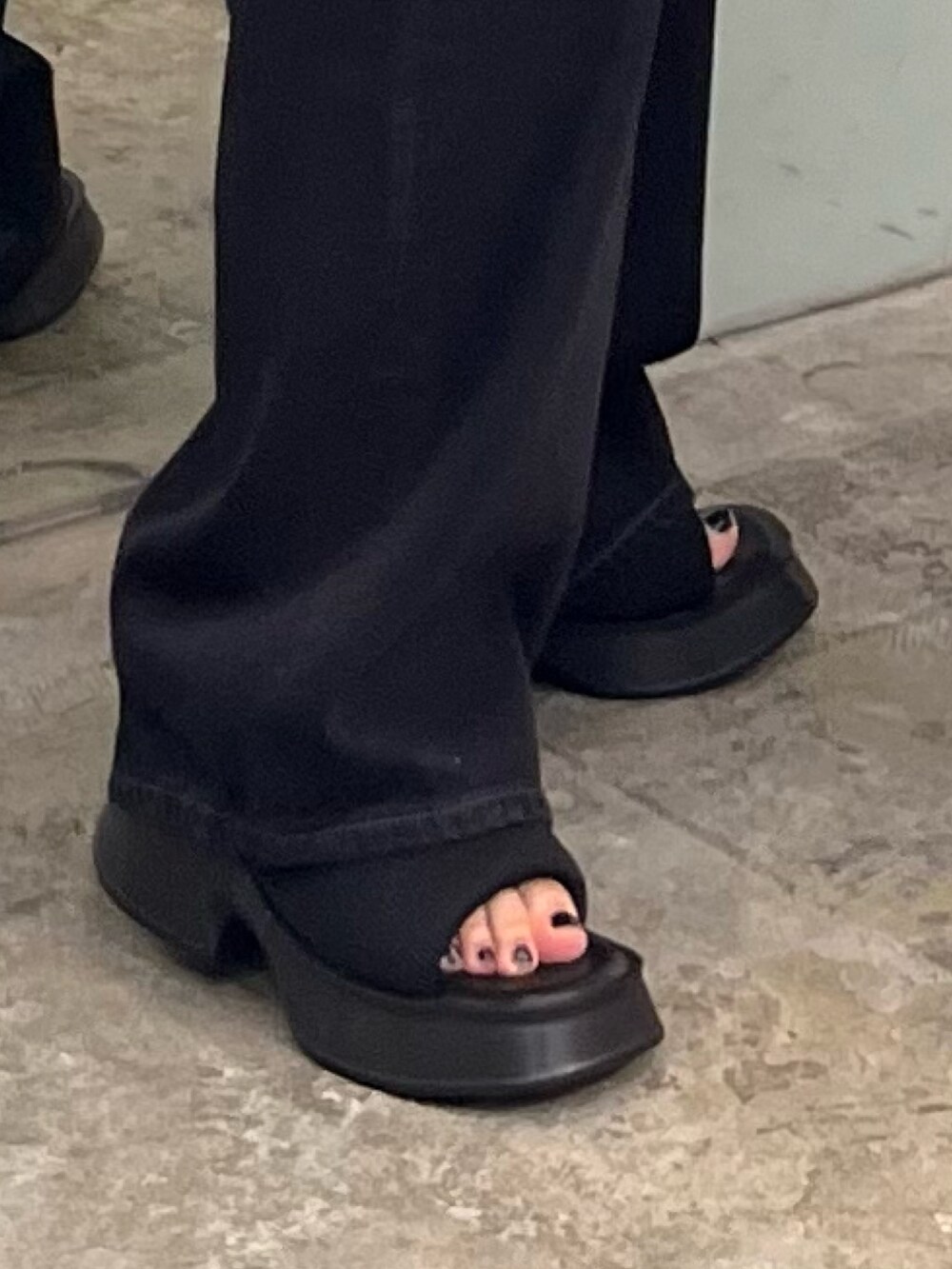 ブラック系のタンクトップ、ブラック系のデニムパンツ、ブラック系のサンダルを着用したレディースの夏コーディネートの7枚目の写真