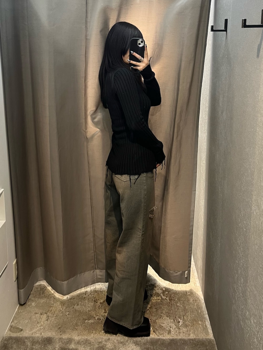 ブラック系のニット/セーター、グレー系のデニムパンツ、ブラック系のブーツを着用したレディースの冬コーディネートの3枚目の写真