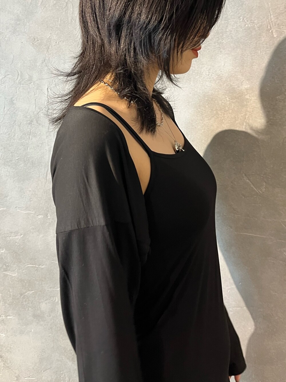 ブラック系のブーツ、パープル系のハンドバッグ、ブラック系のワンピースを着用したレディースの春コーディネートの3枚目の写真