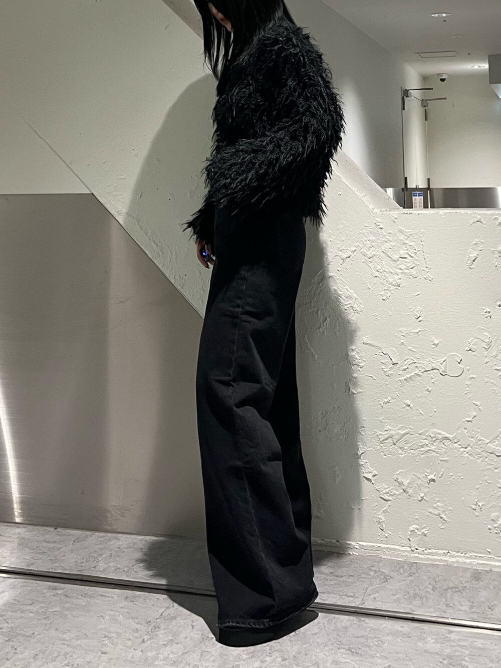 ブラック系のカーディガン/ボレロ、ブラック系のデニムパンツ、ブラック系のブーツを着用したレディースの秋コーディネートの3枚目の写真