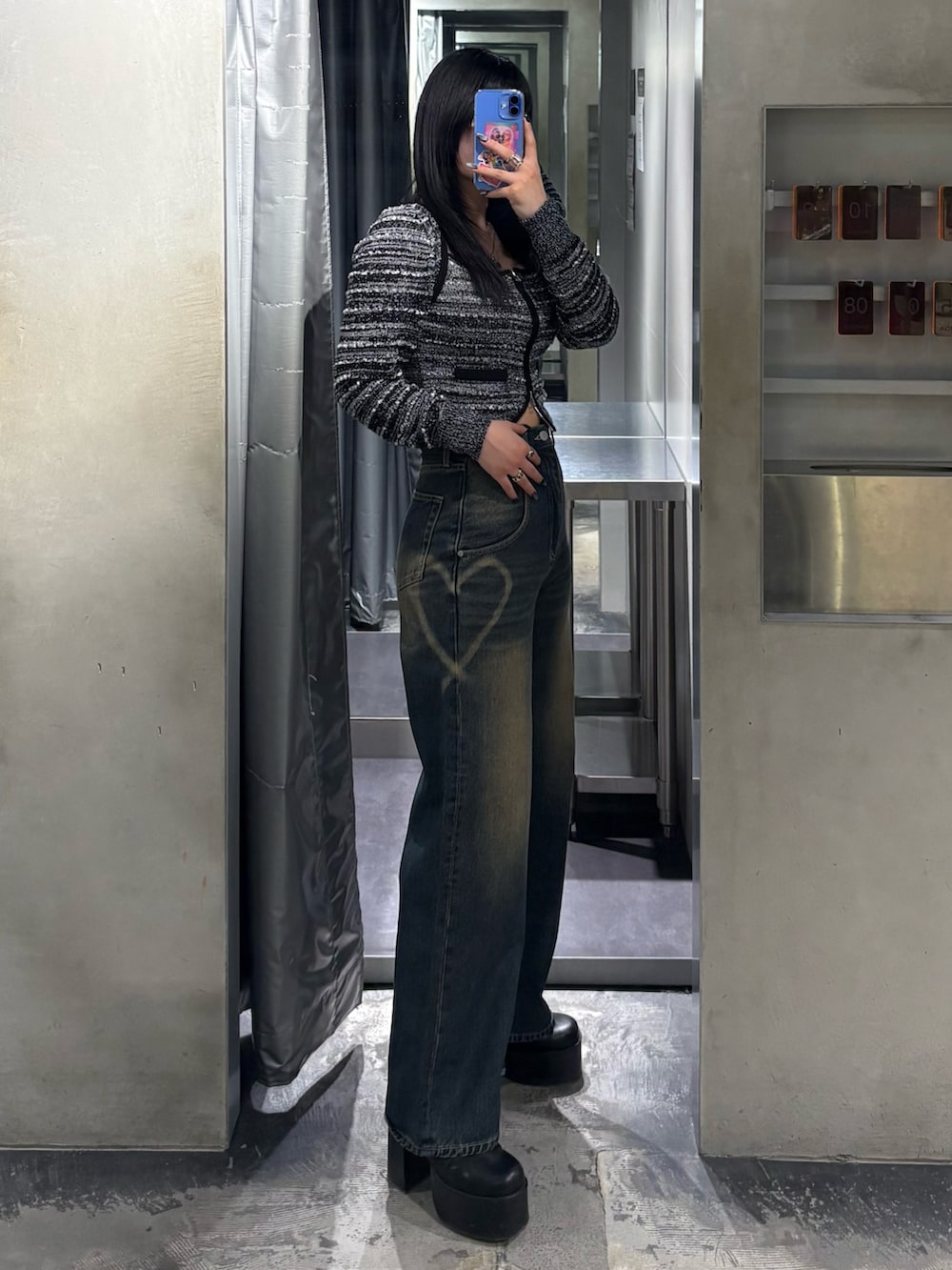 ブラック系のニット/セーター、ブルー系のデニムパンツ、ブラック系のブーツを着用したレディースの冬コーディネートの2枚目の写真