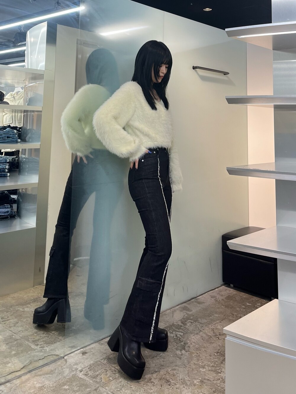 ホワイト系のニット/セーター、ブラック系のデニムパンツ、ブラック系のブーツを着用したレディースの秋コーディネートの2枚目の写真