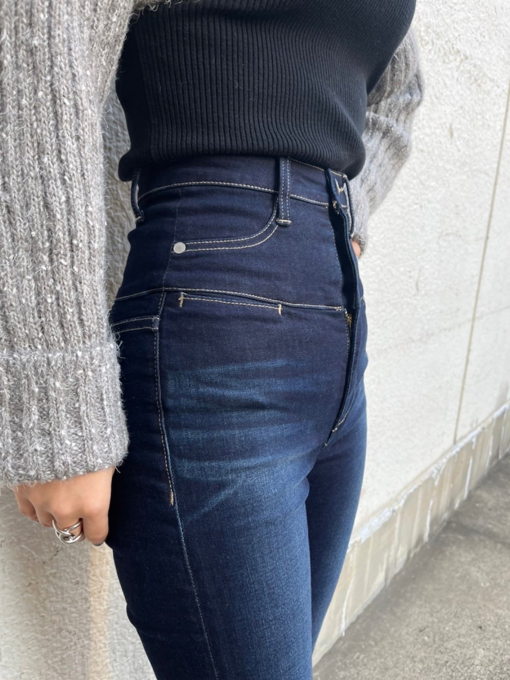 ブラック系のニット/セーター、ブルー系のデニムパンツ、ブラック系のローファーを着用したレディースの秋コーディネートの9枚目の写真