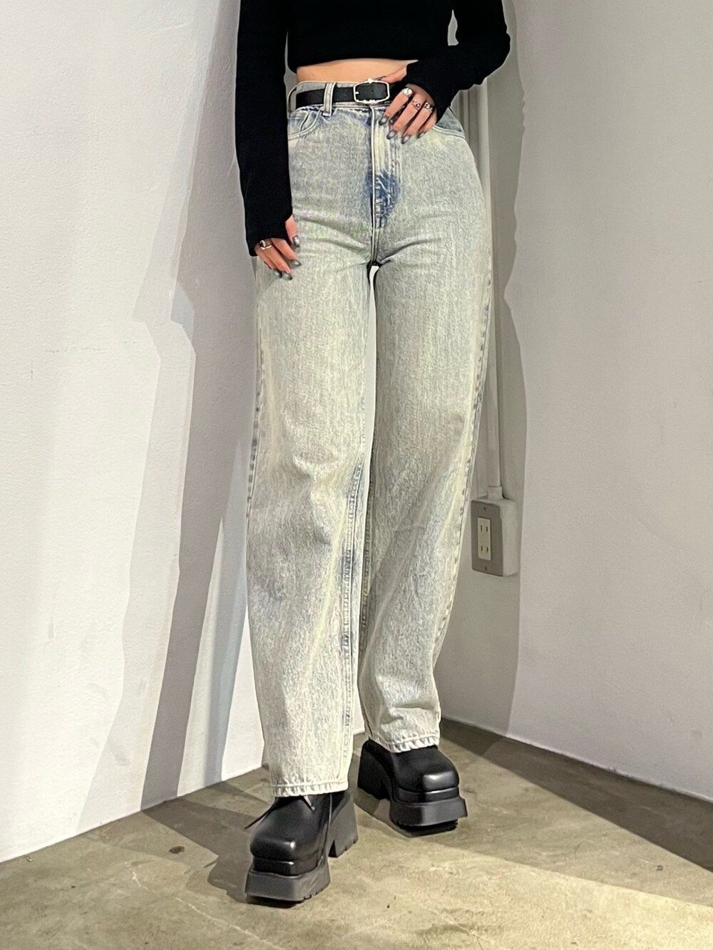 ブラック系のTシャツ/カットソー、ブラック系のブーツ、ブルー系のデニムパンツを着用したレディースの春コーディネートの6枚目の写真