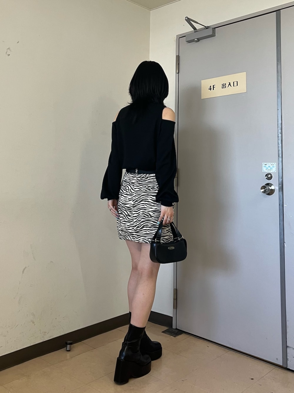 ブラック系のTシャツ/カットソー、その他のスカート、ブラック系のハンドバッグを着用したレディースの春コーディネートの4枚目の写真