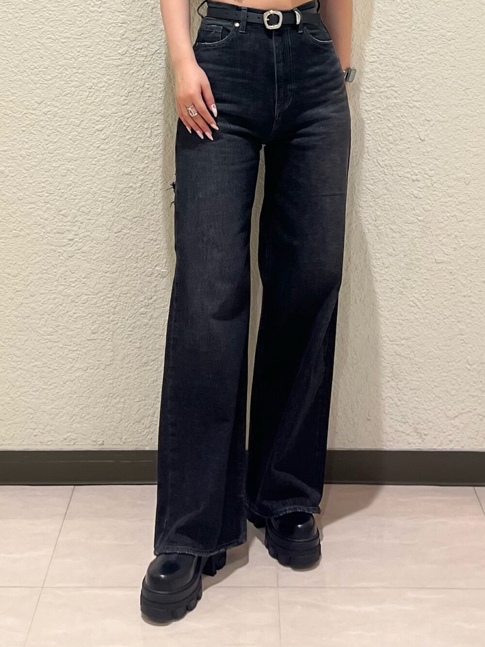 ブルー系のニット/セーター、ブラック系のデニムパンツ、ブラック系のブーツを着用したレディースの夏コーディネートの5枚目の写真