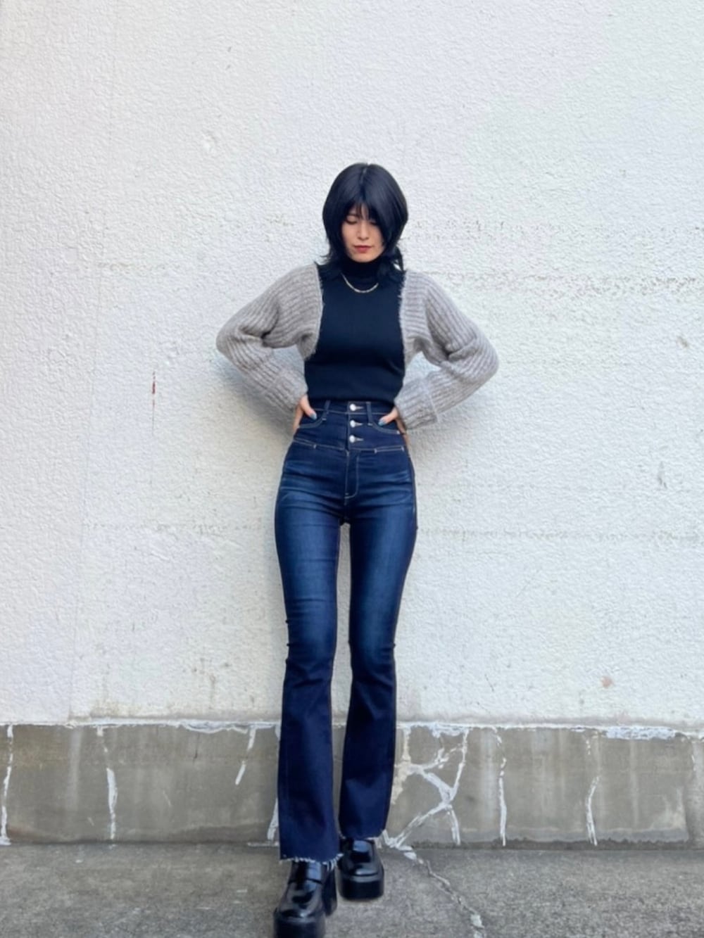 ブラック系のニット/セーター、ブルー系のデニムパンツ、ブラック系のローファーを着用したレディースの秋コーディネートの2枚目の写真