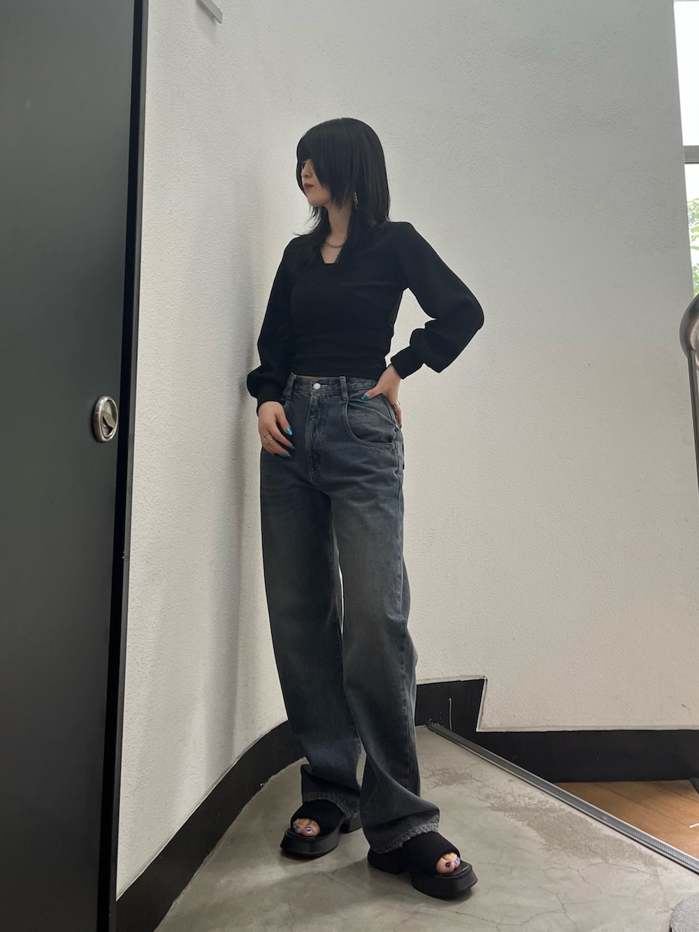 ブルー系のデニムパンツ、ブラック系のサンダル、シルバー系のネックレスを着用したレディースの夏コーディネートの2枚目の写真