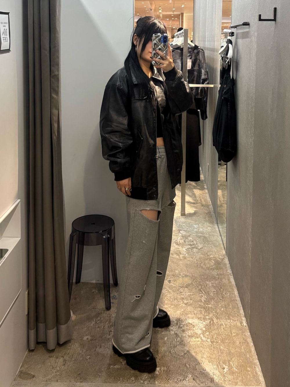 ブラック系のブルゾン、グレー系のスウェットパンツ、ブラック系のブーツを着用したレディースの秋コーディネートの2枚目の写真