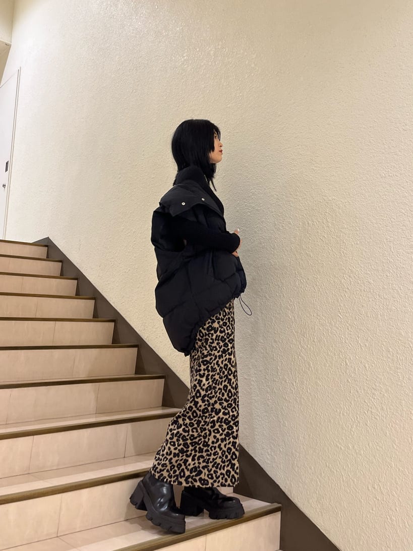 ブラック系のブーツ、ブラック系のニット/セーター、ブラック系のダウンベストを着用したレディースの秋コーディネートの3枚目の写真