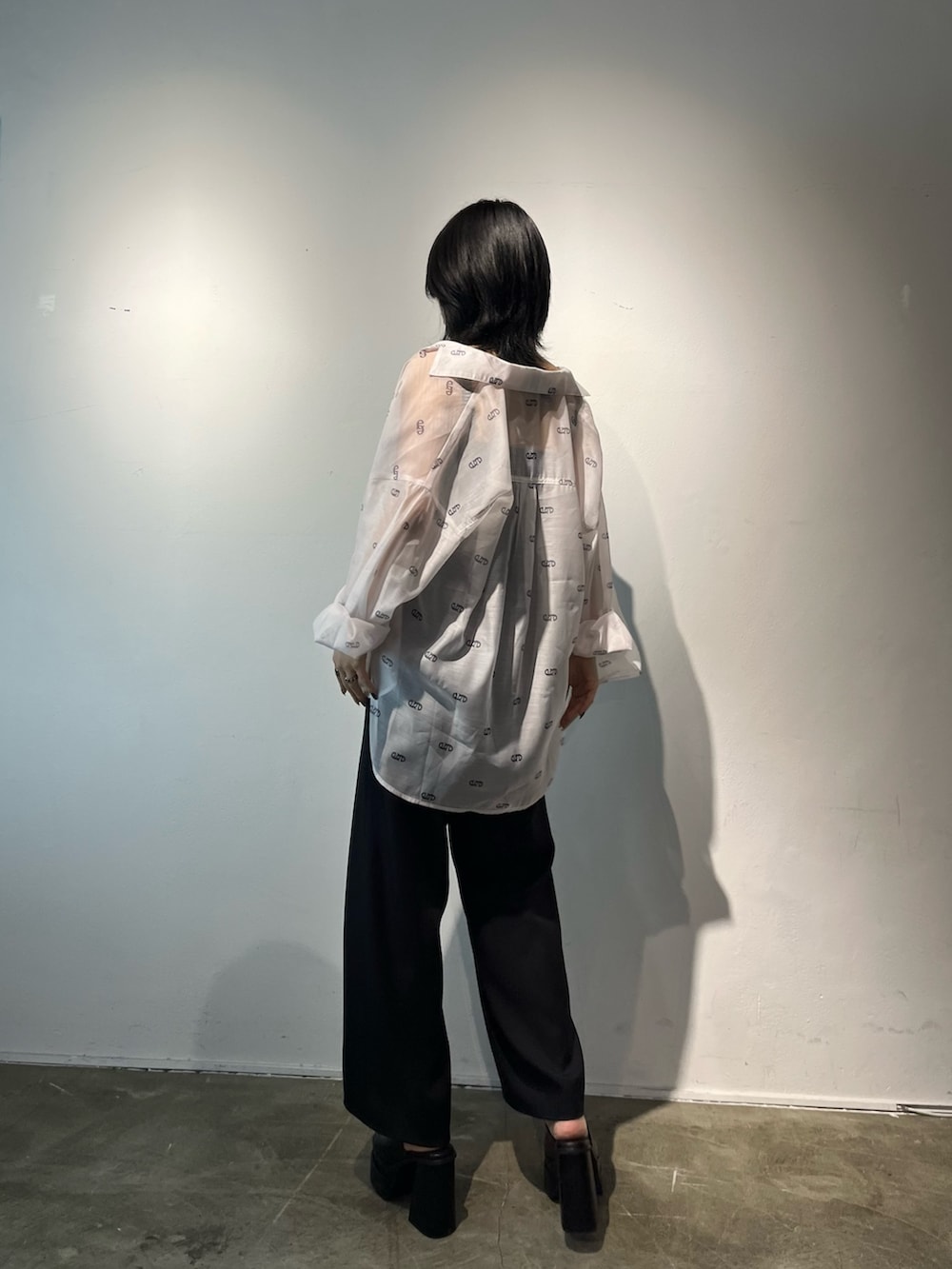 ブラック系のサロペット/オーバーオール、ホワイト系のシャツ/ブラウス、ブラック系のサンダルを着用したレディースの春コーディネートの3枚目の写真
