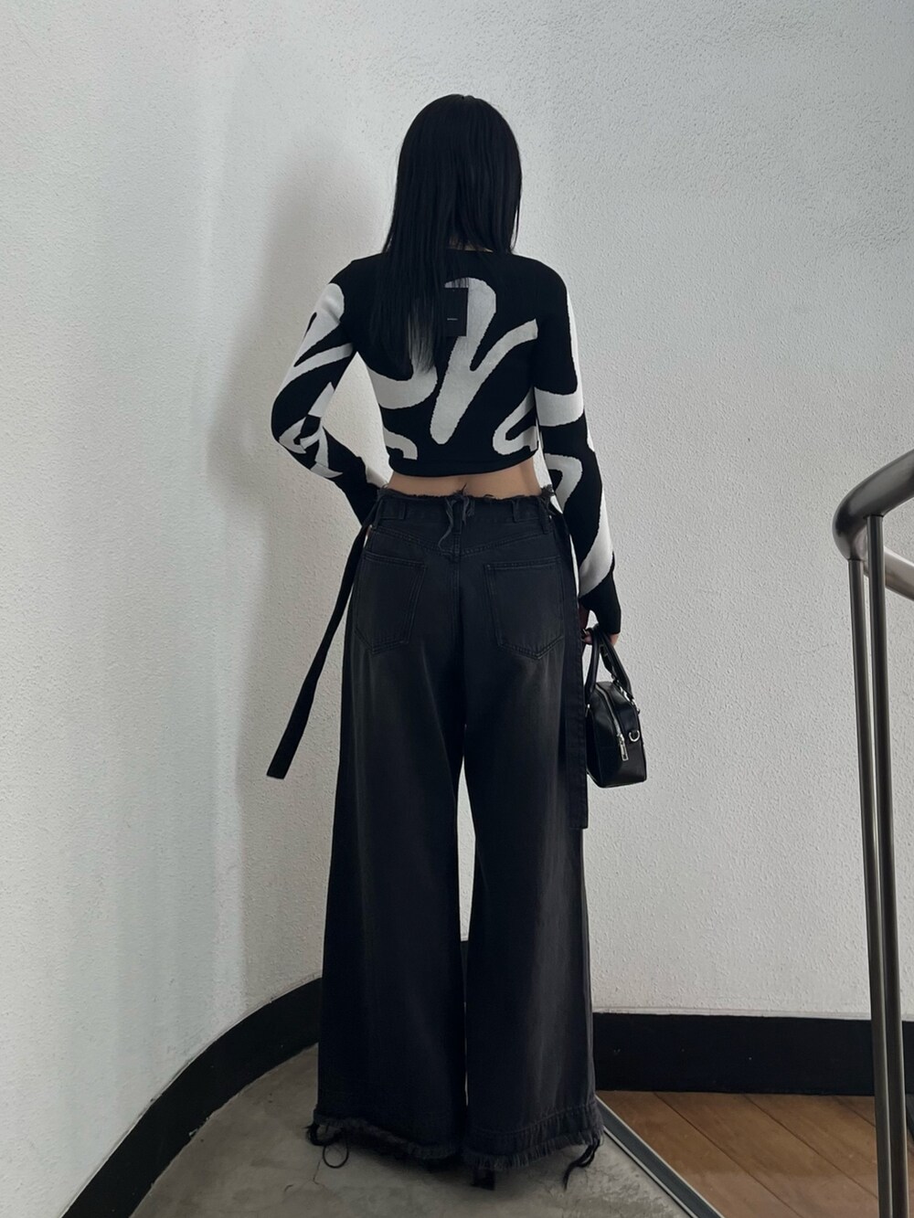 ブラック系のキャミソール、その他のニット/セーター、ブラック系のデニムパンツを着用したレディースの冬コーディネートの4枚目の写真