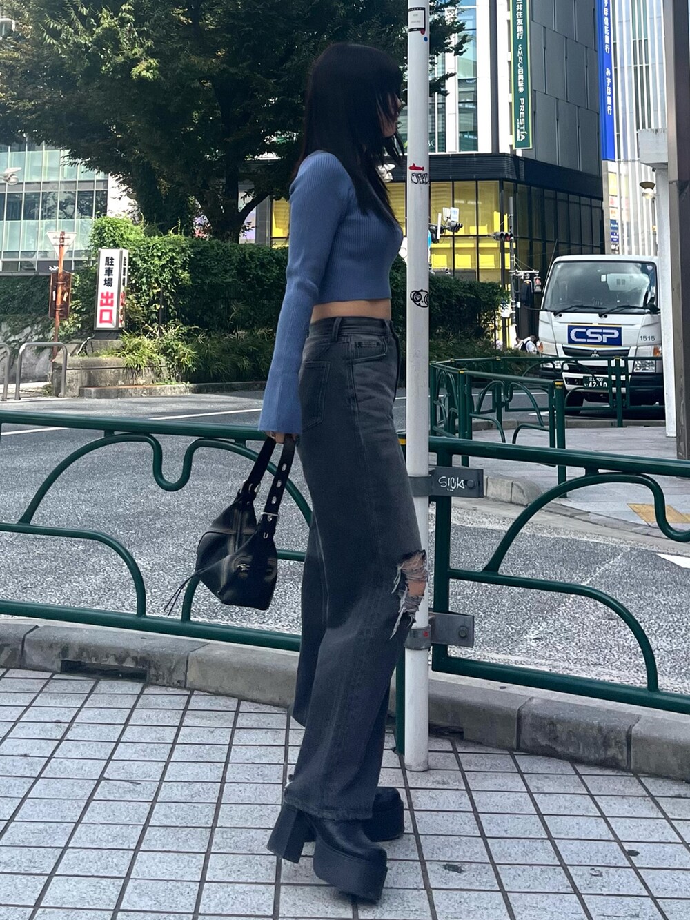 ブルー系のニット/セーター、グレー系のデニムパンツ、ブラック系のブーツを着用したレディースの秋コーディネートの3枚目の写真