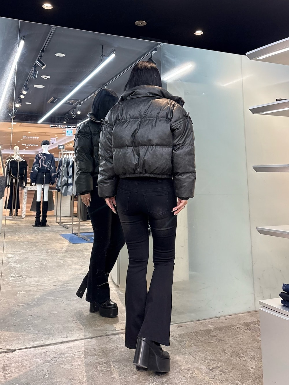 グレー系のニット/セーター、その他のダウンジャケット/コート、ブラック系のデニムパンツを着用したレディースの冬コーディネートの3枚目の写真