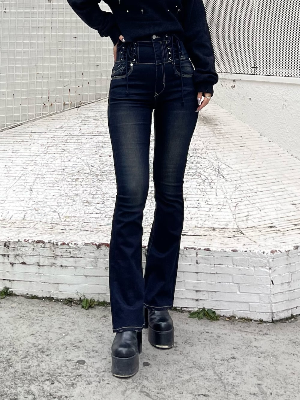 ブラック系のニット/セーター、ブルー系のデニムパンツ、ブラック系のブーツを着用したレディースの冬コーディネートの5枚目の写真