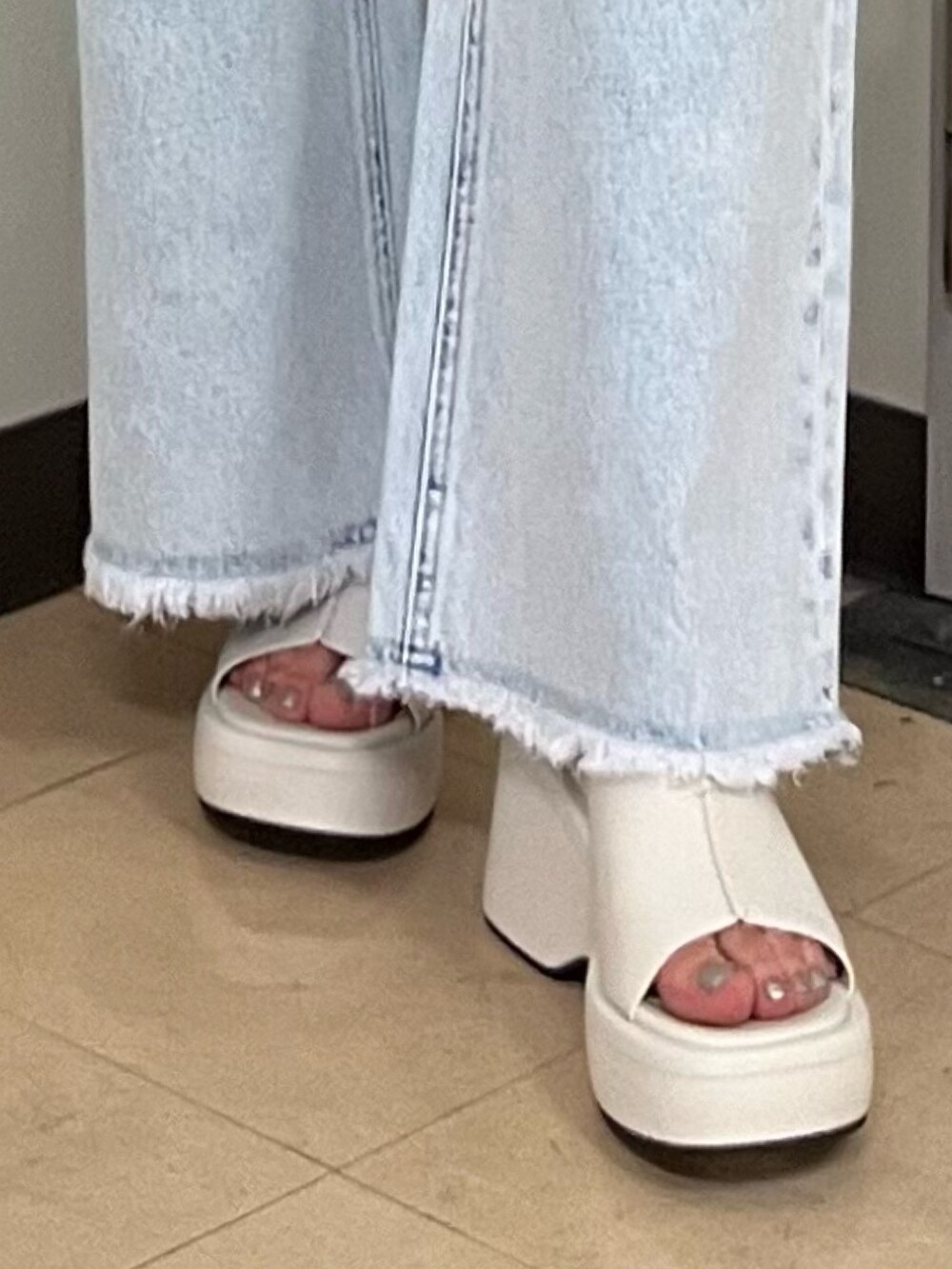 ホワイト系のキャミソール、ブルー系のデニムパンツ、ブラック系のカーディガン/ボレロを着用したレディースの春コーディネートの5枚目の写真