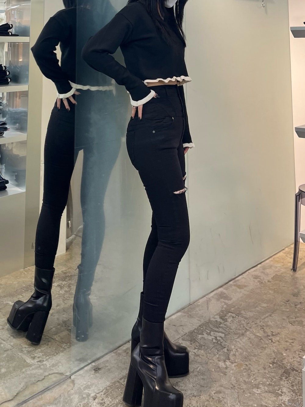 ブラック系のニット/セーター、ブラック系のデニムパンツ、ブラック系のブーツを着用したレディースの冬コーディネートの2枚目の写真