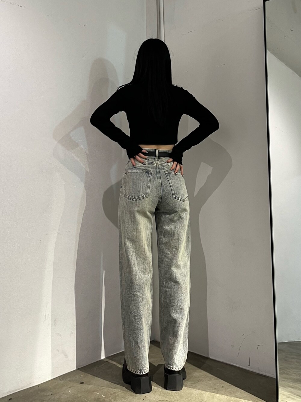 ブラック系のTシャツ/カットソー、ブラック系のブーツ、ブルー系のデニムパンツを着用したレディースの春コーディネートの4枚目の写真