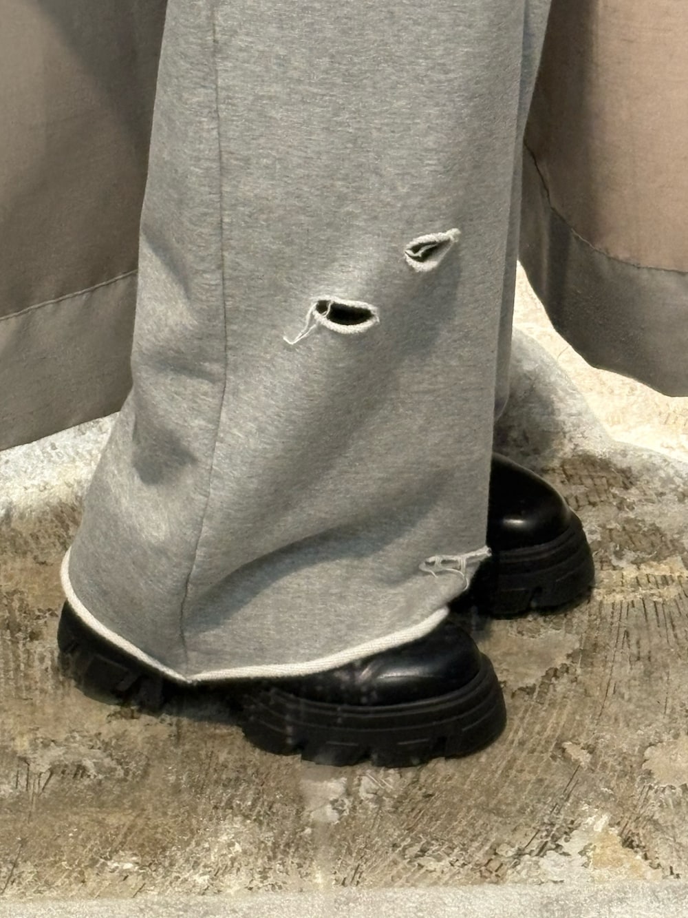 ブラック系のブルゾン、グレー系のスウェットパンツ、ブラック系のブーツを着用したレディースの秋コーディネートの6枚目の写真