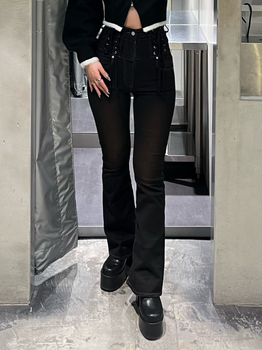 ブラック系のニット/セーター、ブラック系のデニムパンツ、ブラック系のブーツを着用したレディースの冬コーディネートの5枚目の写真