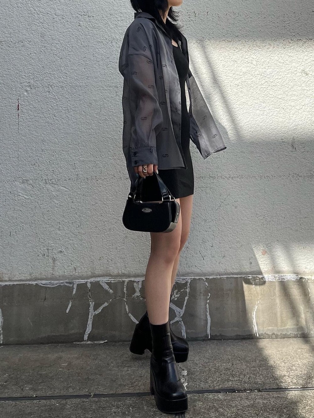 ブラック系のワンピース、ブラック系のハンドバッグ、ブラック系のシャツ/ブラウスを着用したレディースの春コーディネートの2枚目の写真