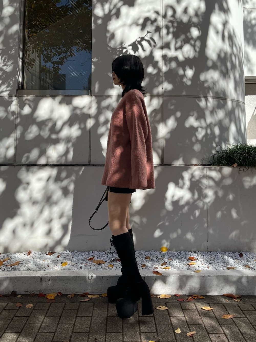 ピンク系のニット/セーター、ブラック系のスカート、ブラック系のハンドバッグを着用したレディースの冬コーディネートの4枚目の写真