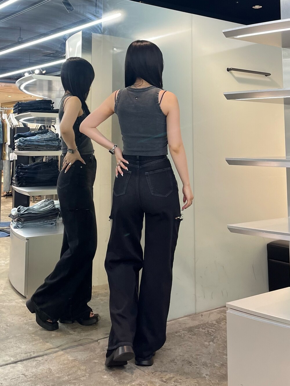 ブラック系のタンクトップ、ブラック系のデニムパンツ、ブラック系のサンダルを着用したレディースの夏コーディネートの4枚目の写真