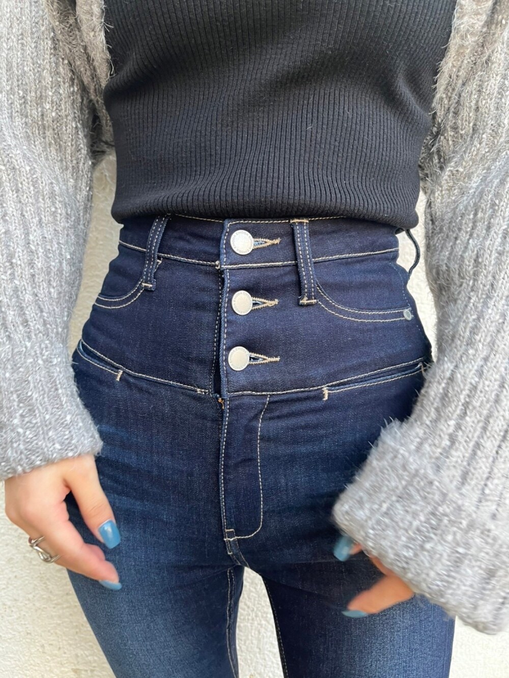 ブラック系のニット/セーター、ブルー系のデニムパンツ、ブラック系のローファーを着用したレディースの秋コーディネートの8枚目の写真