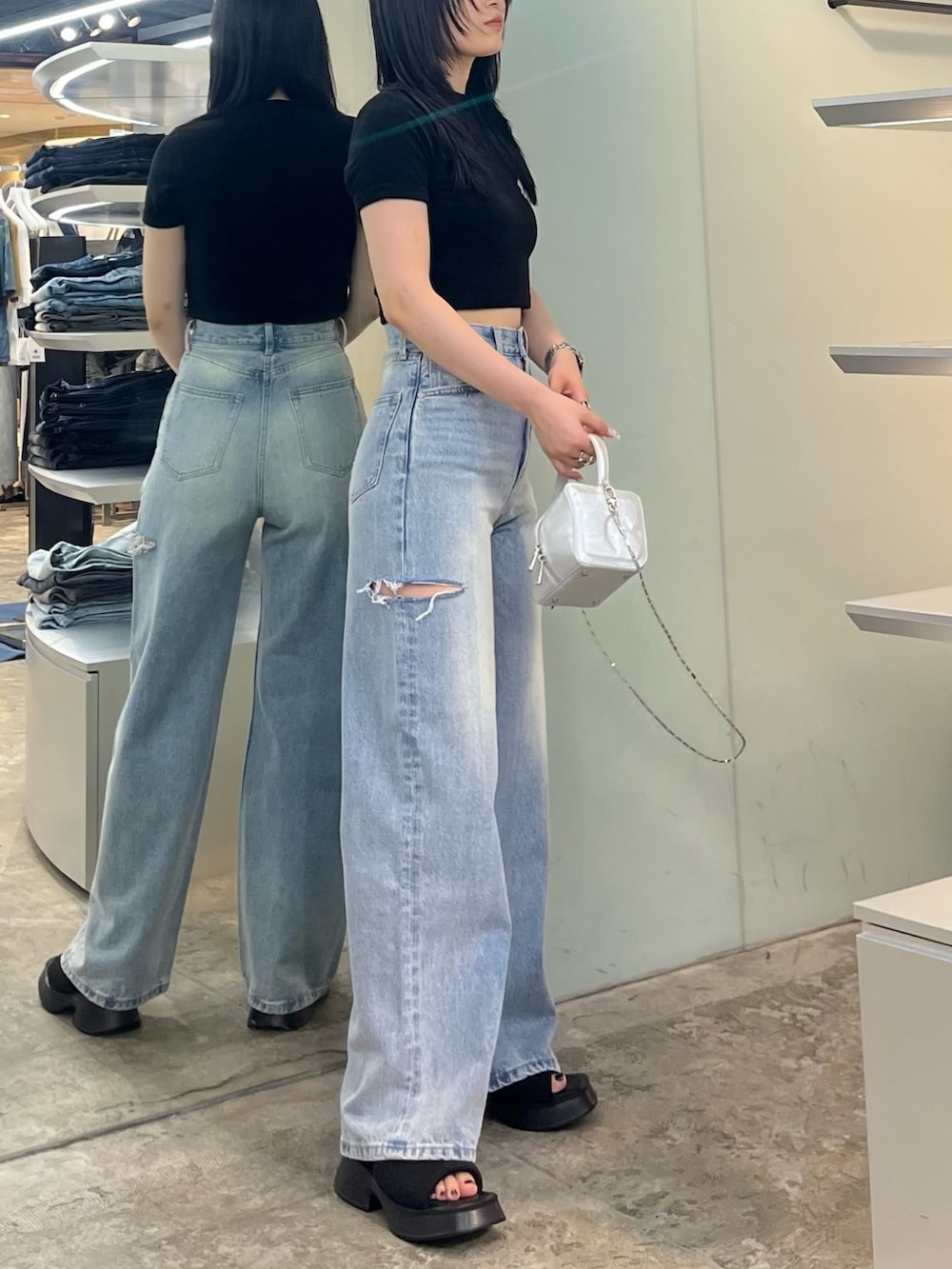 ブラック系のTシャツ/カットソー、ブルー系のデニムパンツ、シルバー系のハンドバッグを着用したレディースの夏コーディネートの2枚目の写真