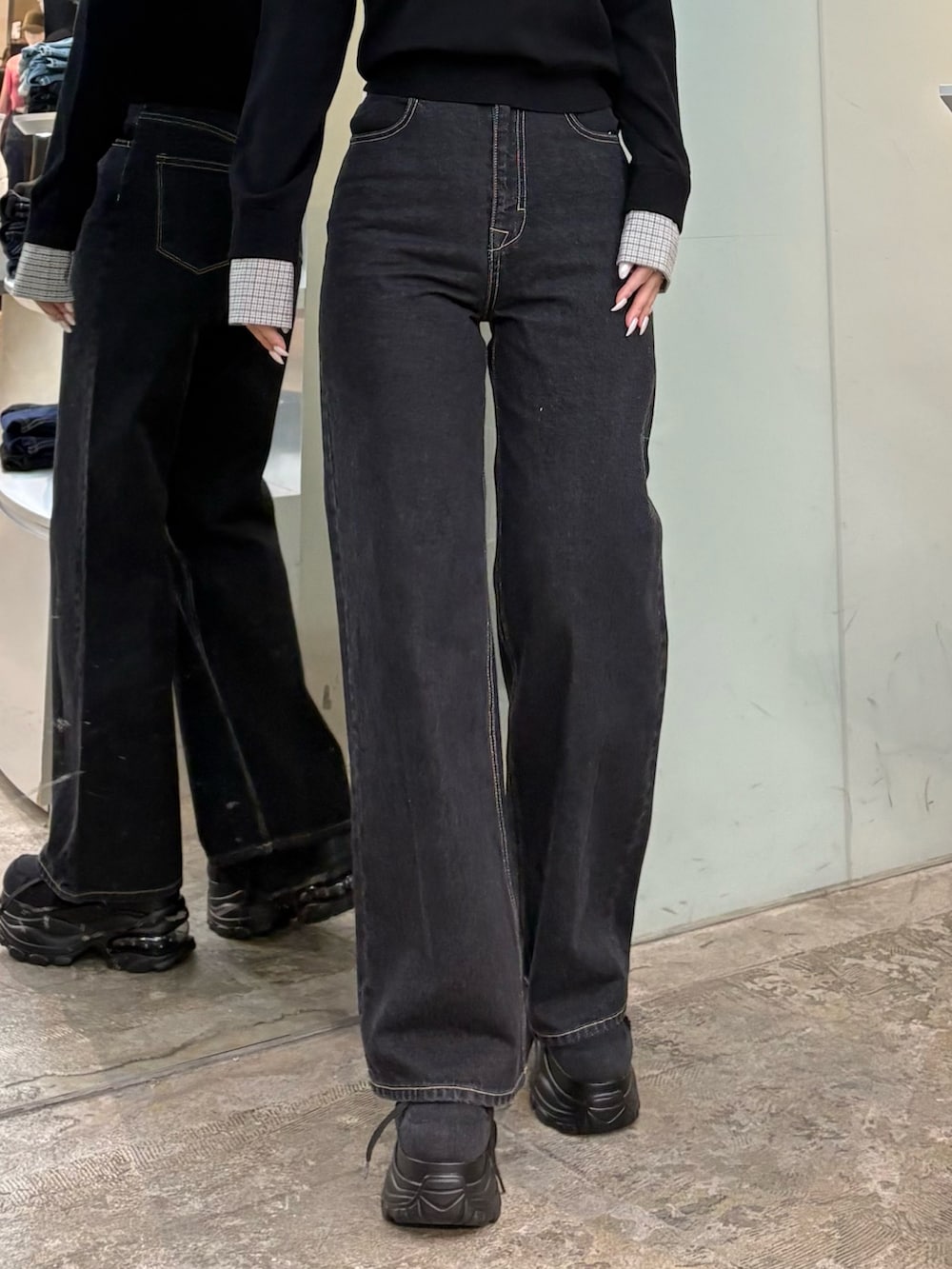 ブラック系のシャツ/ブラウス、ブルー系のデニムパンツ、ブラック系のスニーカーを着用したレディースの冬コーディネートの5枚目の写真