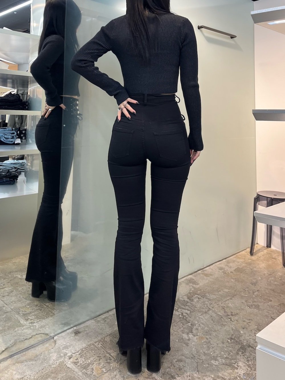 ブラック系のニット/セーター、ブラック系のデニムパンツ、ブラック系のブーツを着用したレディースの冬コーディネートの3枚目の写真