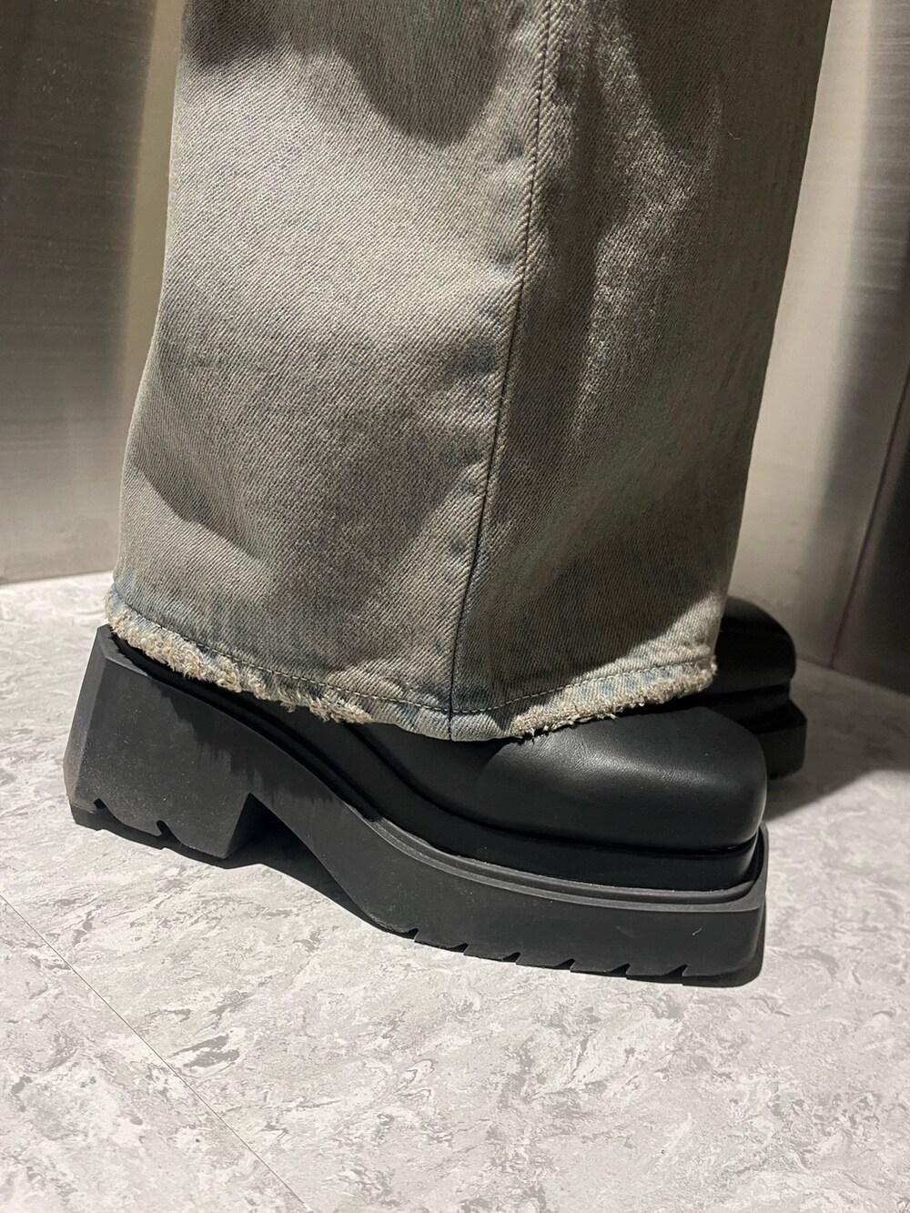 ブラック系のニット/セーター、グレー系のデニムパンツ、ブラック系のブーツを着用したレディースの冬コーディネートの7枚目の写真