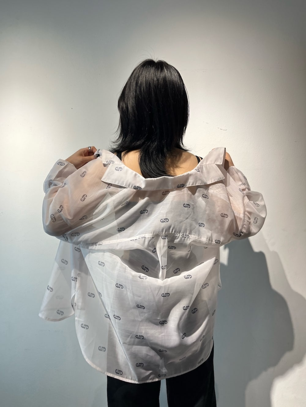 ブラック系のサロペット/オーバーオール、ホワイト系のシャツ/ブラウス、ブラック系のサンダルを着用したレディースの春コーディネートの5枚目の写真