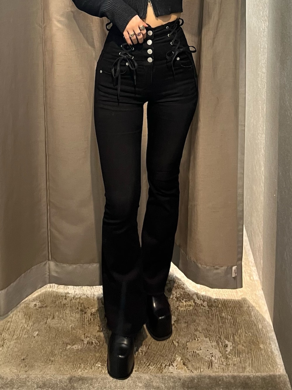 ブラック系のニット/セーター、ブラック系のデニムパンツ、ブラック系のブーツを着用したレディースの冬コーディネートの6枚目の写真