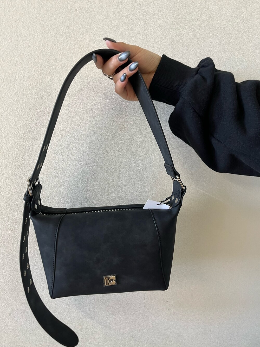 ブラック系のスウェット、ブルー系のデニムパンツ、ブラック系のショルダーバッグを着用したレディースの冬コーディネートの7枚目の写真