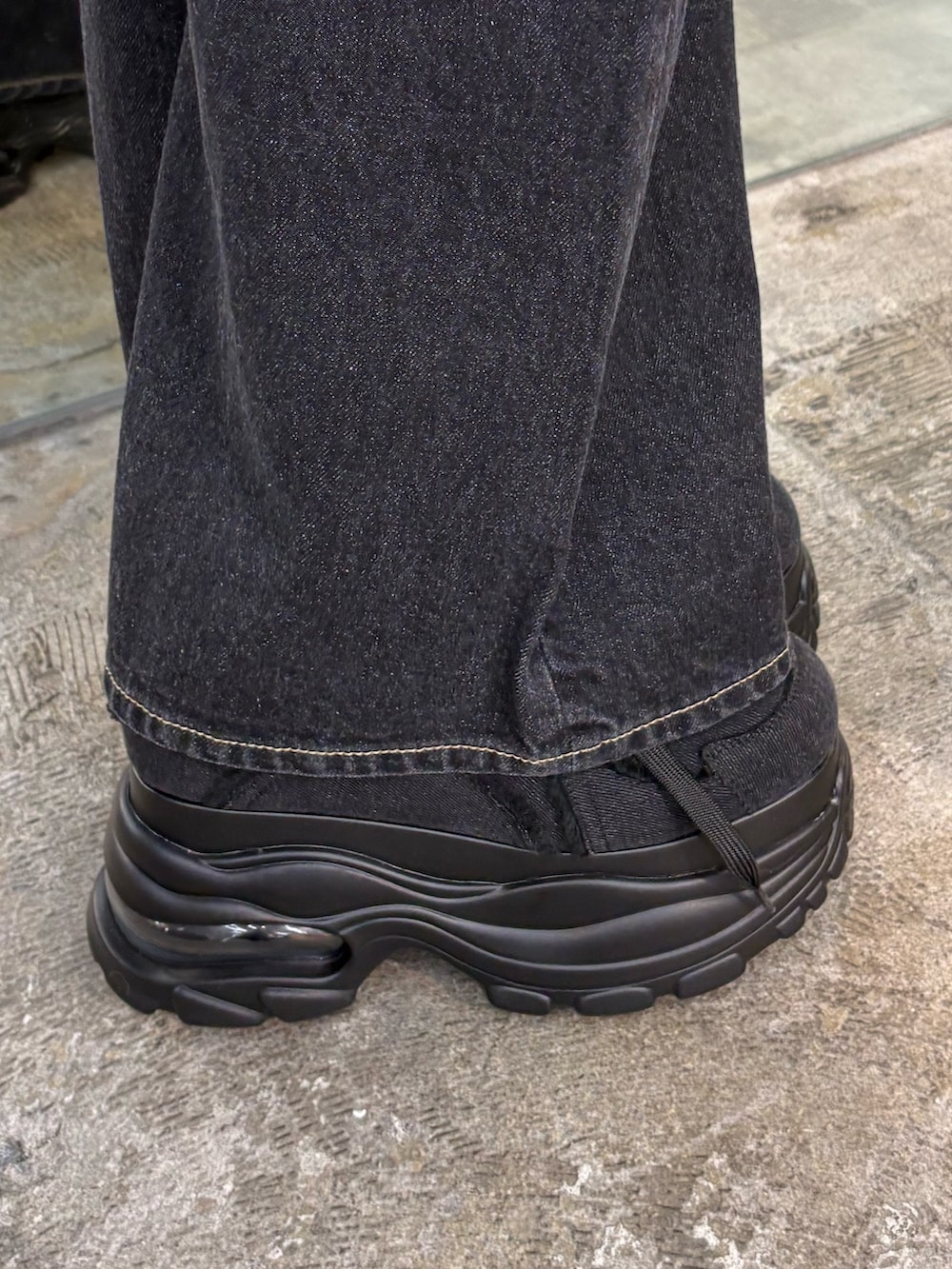 ブラック系のシャツ/ブラウス、ブルー系のデニムパンツ、ブラック系のスニーカーを着用したレディースの冬コーディネートの6枚目の写真